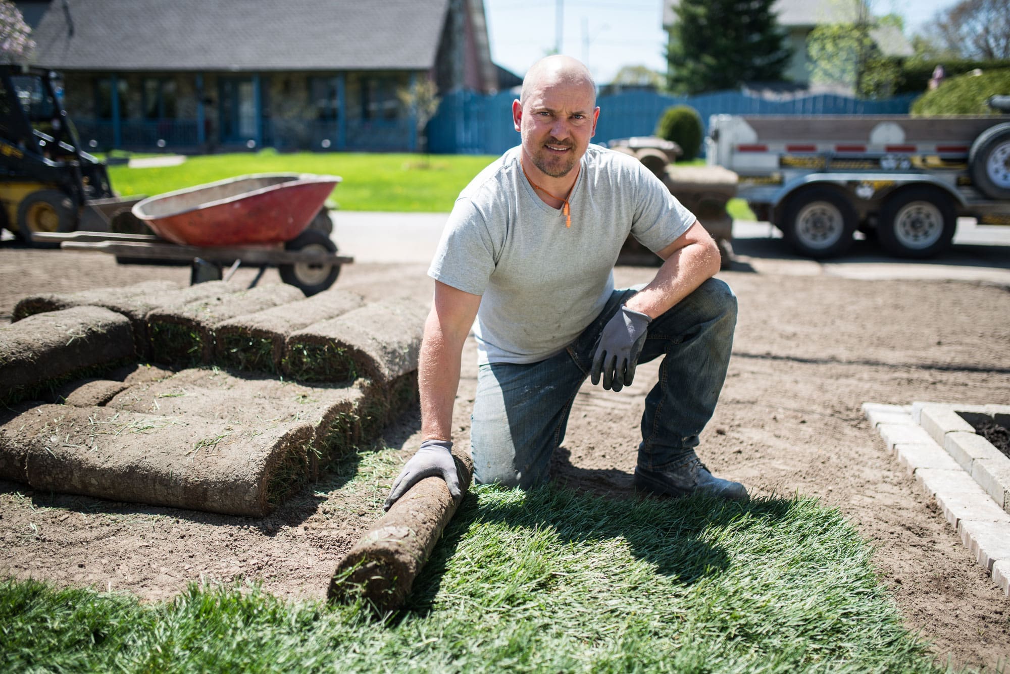 Landscaper-laying-sod Landscaper laying sod down in a yard and smiling