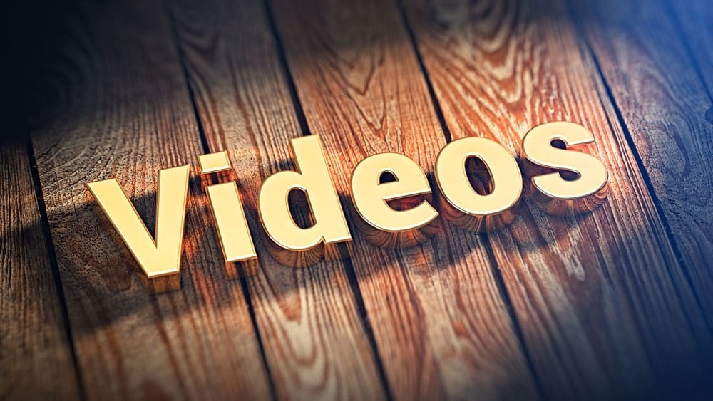 Videos The word "Videos" is lined with gold letters on wooden planks