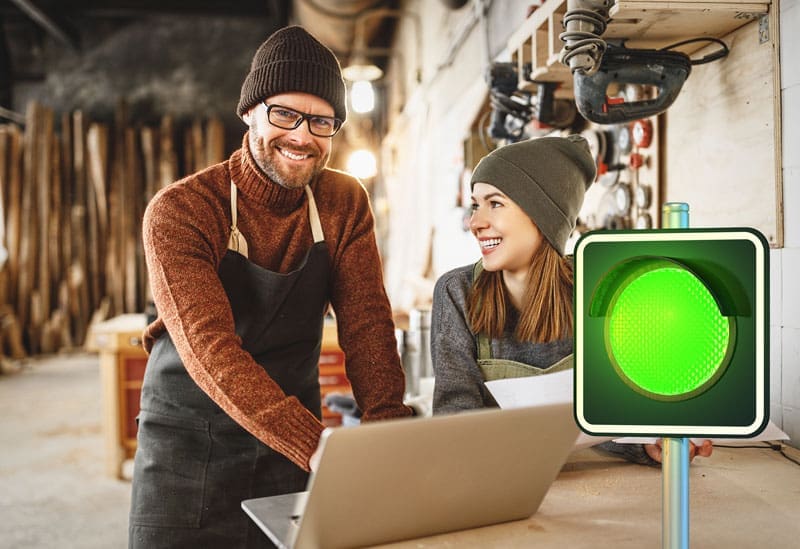 Green-Light-smiling-business-owners 2 business owners smiling and looking at their business profile with an green traffic light overlapping the image