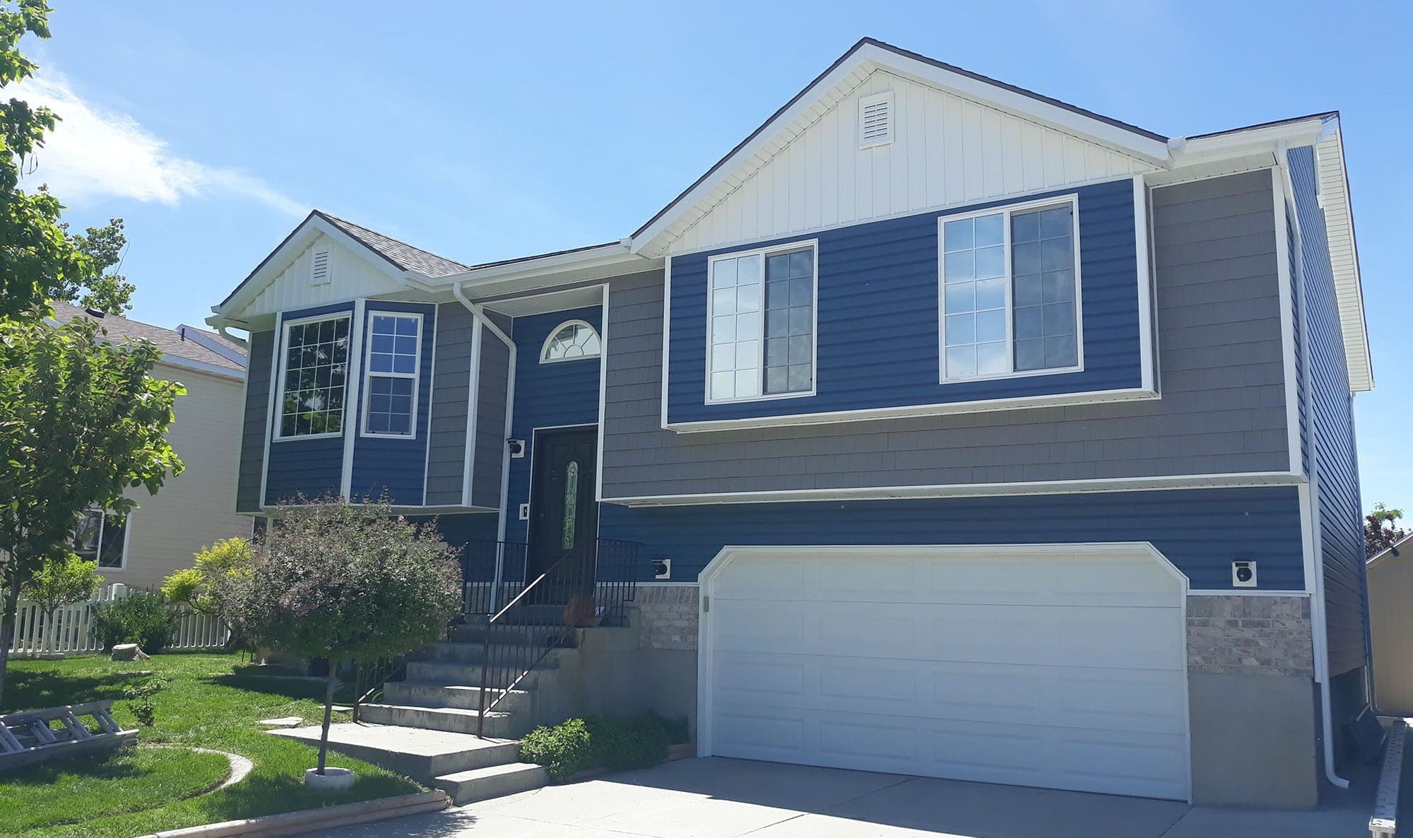 Split-level-home-with-gray-and-blue-siding Siding work done by X-Siding, a ZipLocal client